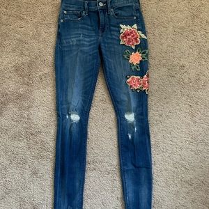 Express embroider flower jeans. Raw hem.